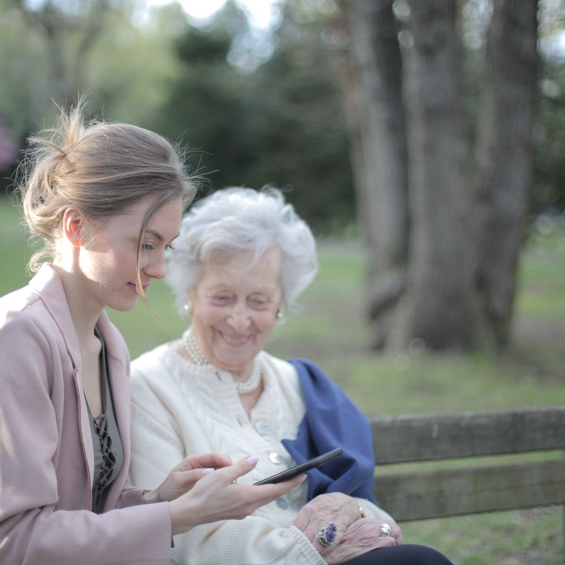 A caregiver sharing a warm moment with a senior outdoors