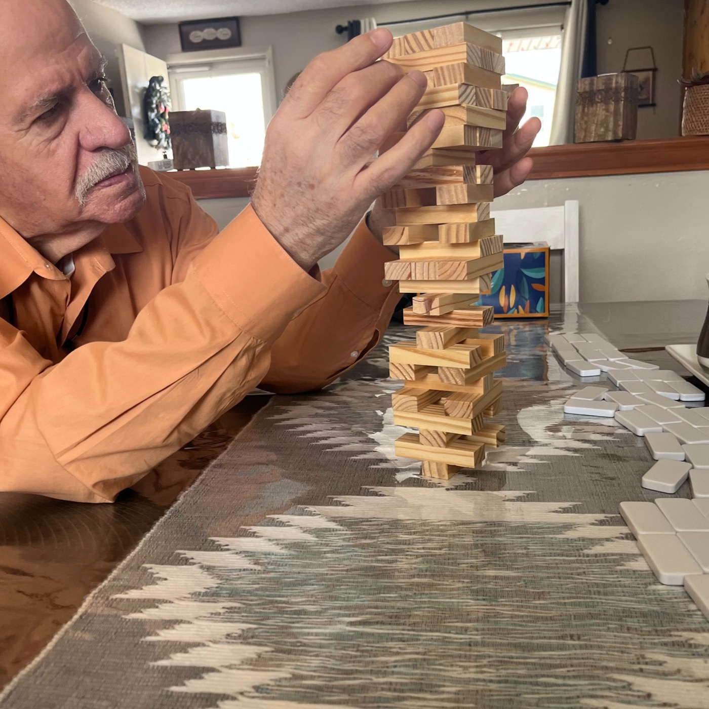 A client playing Jenga at his kitchen counter